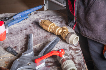 Plumbing tools and brass fittings on a workbench in a workshop