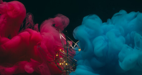 Fume explosion. Light bulb. Glowing garland in damaged glass. Pink blue smoke blend color ink on black background abstract night water