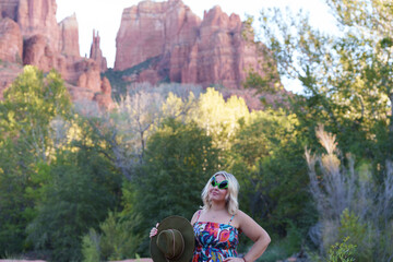 Blonde woman wearing alien sunglasses poses at Crescent Moon Ranch with Cathedral Rock in Sedona Arizona