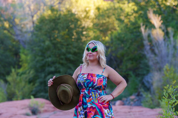 Blonde woman wearing alien sunglasses poses at Crescent Moon Ranch with Cathedral Rock in Sedona Arizona