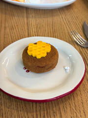 Round dessert with honeycomb decoration placed on white plate. Sweet bakery item presenting texture, craft, and culinary detail.