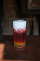 Indulge in a vibrant layered drink with creamy topping, perfect for a refreshing summer treat or a cool beverage campaign, delicious and aesthetically pleasing