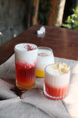 Refreshing summer cocktails with colorful layers and creamy foam, perfect for tropical vibes and vacation relaxation at a trendy bar or restaurant