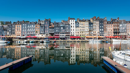Vue du port de Honfleur en Normandie, avec un reflet des immeubles dans l'eau, France