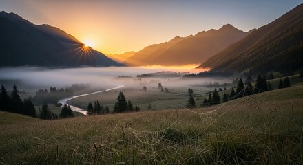 A scenic landscape view of mountains with fog and a river at sunrise with a grassy foreground