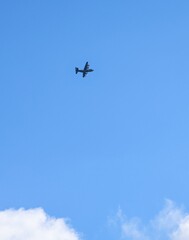 Military cargo aircraft flying across blue sky