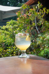 Refreshing lychee cocktail with mint and lemon wedge on sunlit table, perfect for summer promotions and tropical vacation ads, vibrant and inviting