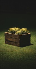 Wooden planter box with yellow flowers on green grass at night.