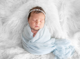 Baby Sleeping In Blue Swaddle During Newborn Photoshoot