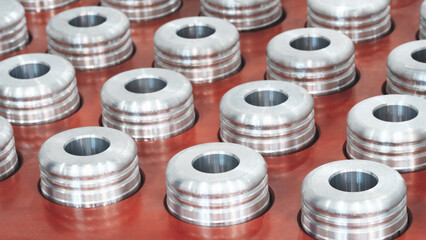 Quality testing of metal parts, round metal parts lying in rows on a quality control test table, industrial concept background.