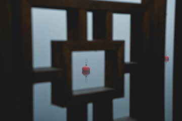 A red buoy floating on a misty ocean during crispy fall morning.