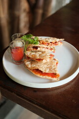Delicious quesadilla stack with vibrant red dipping sauce and creamy aioli, perfect for food blogs, restaurant menus, and culinary presentations