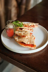 Enjoy delicious quesadillas with vibrant tomato sauce and creamy dip for a delightful meal, perfect for sharing with friends and family during a casual gathering
