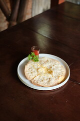 Crispy cheese tortilla with vibrant tomato sauce and fresh parsley garnish ready for a delicious bite on rustic wooden table adding warmth to the scene