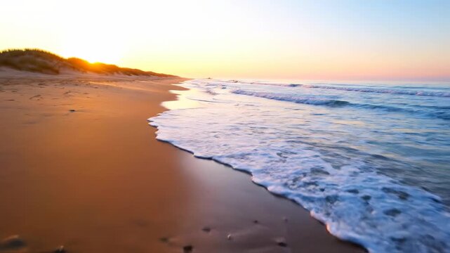 Wide, sweeping dolly shot over a tranquil beach as gentle waves from the rising tide meet the shore, bathed in warm sunrise light calm, background, shore