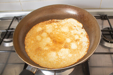 Homemade Pancake in Frying Pan on Gas Stove, First Crepe Cooking at Home, Real Kitchen Atmosphere