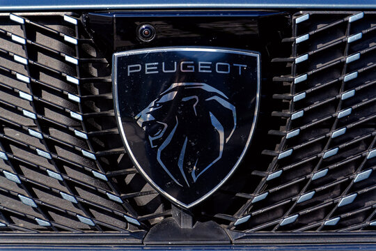 Peugeot company logo on car in front of dealership building on October 18, 2025 in Prague, Czech Republic.