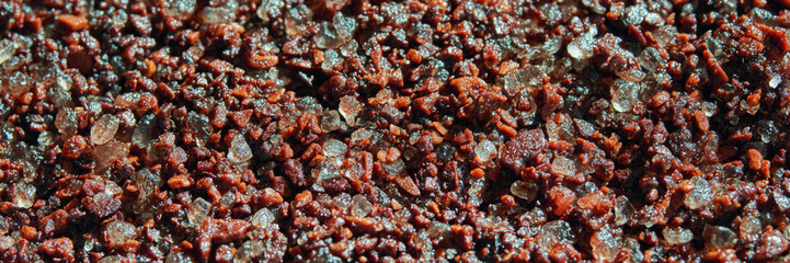 Close-up of coarse grained brown and white rock salt crystals with sparkling texture.
