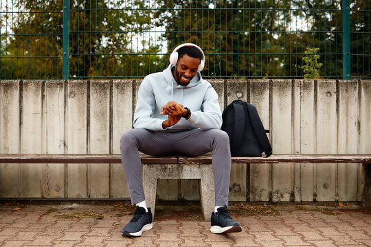 Man checking smartwatch data during workout break on bench
