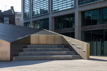 Modern geometric staircase and public space surrounded by new office buildings in London.