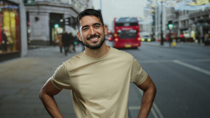 Young man standing confidently in an urban street with a background of iconic red buses, showcasing a charming smile and relaxed posture in a cosmopolitan city scene