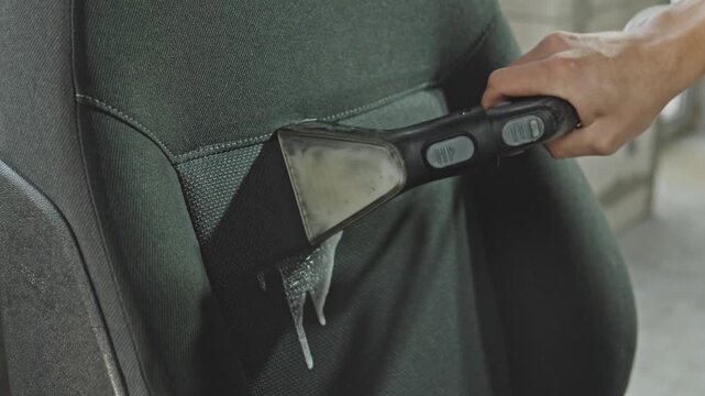 Cleaning process of car seat, removing dirt and stains using washing vacuum cleaner. Person cleaning car seat. The result is a fresh, clean interior that feels brand new