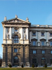 Obraz premium Hofburg Palace Vienna fragment, statuary-adorned pediment and rich texture of stone facade, neoclassical style in golden hour light