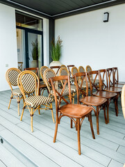 Experience a chic and comfortable outdoor seating arrangement that showcases a beautiful combination of elegant wooden chairs and stylish wicker chairs, perfect for any patio or garden setting