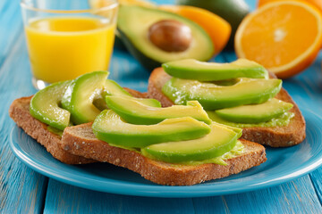 Healthy kid's breakfast with whole-grain toast, avocado slices, and orange juice.