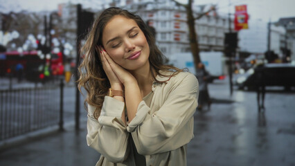 Fototapeta premium Hispanic woman in beige shirt rests head on hands on wet street beneath blurred traffic lights; serenity.