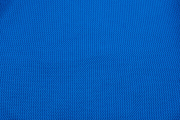Fototapeta premium A macro texture of blue cotton jersey with a small repeating pattern. An ideal backdrop for presentations on design, fashion, sportswear, or the textile industry.