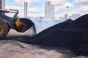 Heavy Machinery Loading Black Aggregate Material at the Construction Site for Development