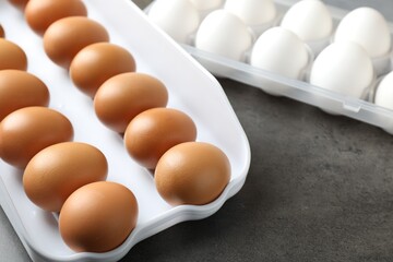 Raw chicken eggs on grey table, closeup