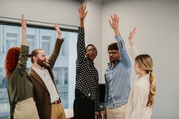 Diverse business team raising hands showing participation