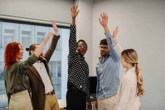 Diverse business team raising hands showing participation