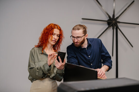 Business colleagues discussing data using smartphone