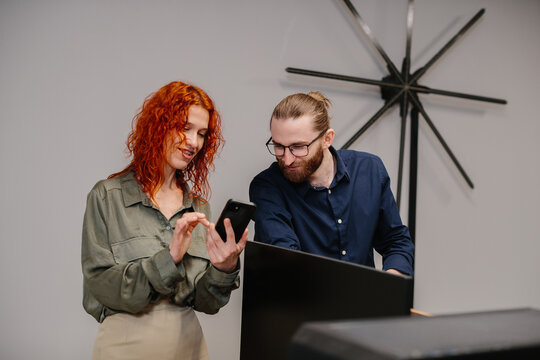 Colleagues collaborating on mobile device creating business solution - Powered by Adobe