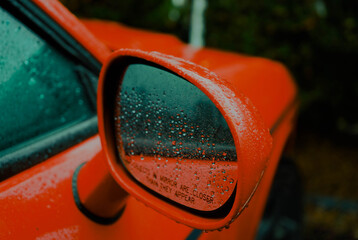Wet side mirror red car