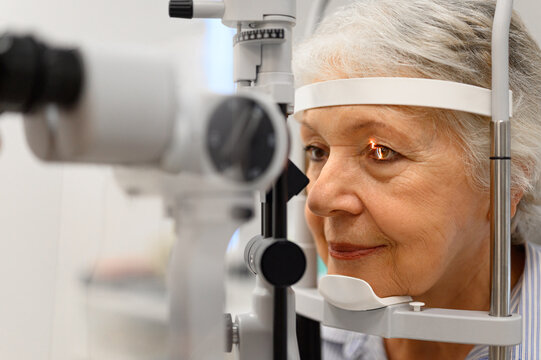 Close-up of mature woman undergoing eye examination with slit lamp for vision checkup at ophthalmology clinic