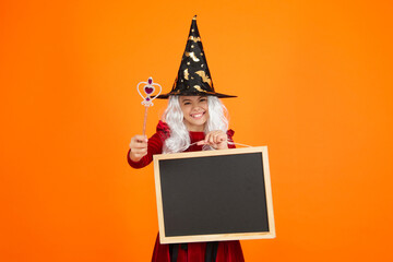 Girl in witch costume hold magic wand. Happy Halloween advertisement. Girl witch in Halloween costume isolated on orange. Halloween party advertisement. Hallows witch girl. Halloween sale