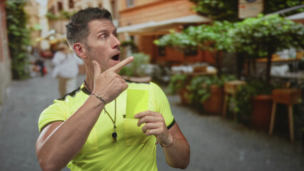Man pointing finger and holding a yellow card on a busy street terrace outside a restaurant,...