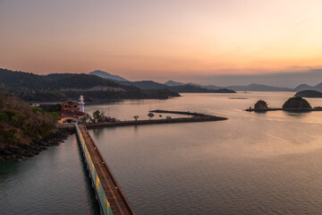 Tranquil view of small tropical islets silhouetted at sunset near Langkawi port, Malaysia. The soft pastel sky reflects on calm sea waters, creating a peaceful and scenic landscape perfect for travel
