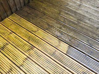 Before and after view of dirt and grime being cleaned from wooden decking using a pressure washer. DIY concept.
