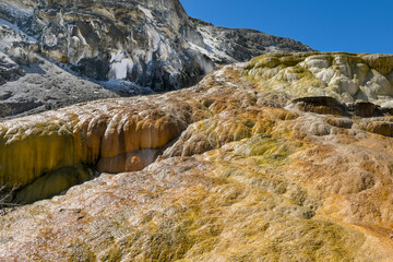 Scenic landscape view of the colourful mineral deposits on Travertine Terraces at the Mammoth Hot Springs in Yellowstone National Park. No people.