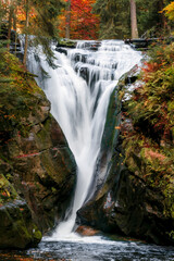 Powerful Waterfall Flowing Through Autumn Forest Rocks