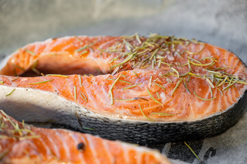 Raw salmon steaks on a baking tray lined with parchment paper.