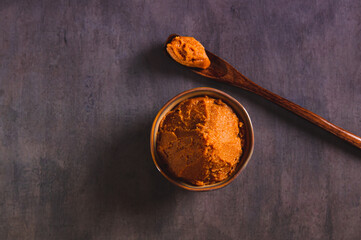 Close up of asian miso paste in a brown bowl on the table top view