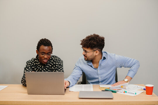 Business colleagues collaborating on laptop in office