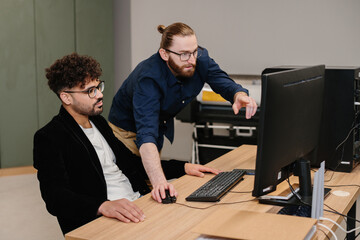 Business colleagues collaborating on computer in office