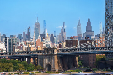 Obraz premium Majestic Brooklyn Bridge graces the NYC skyline. Soaring steel arches frame the cityscape, bathed in warm sunlight. Iconic landmark for travel and architecture projects. wallpaper, 4k 